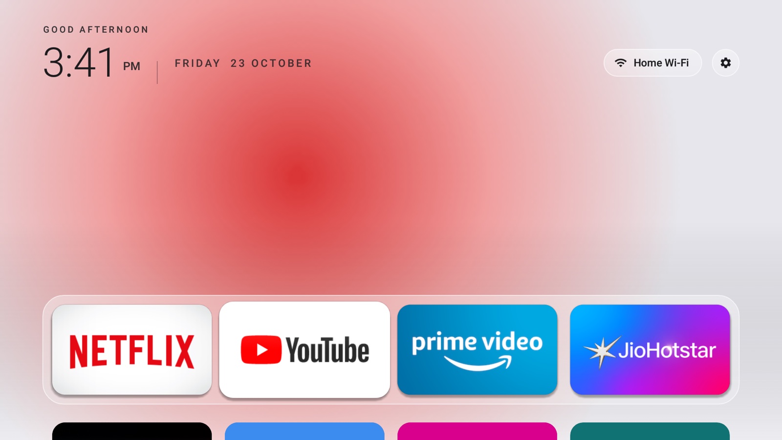 Jisha home screen in Day mode: clock, date, Wi-Fi and Settings buttons, and a frosted dock with Netflix, YouTube, Prime Video and JioHotstar over a soft red glow.